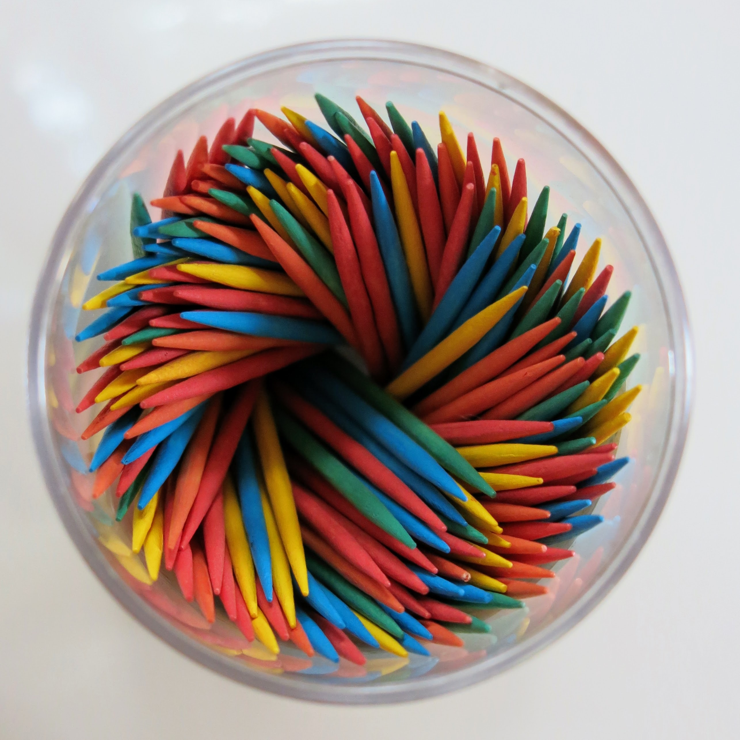 An image of different colored toothpicks in a plastic jar